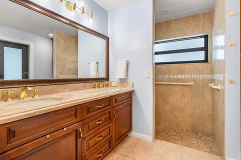 a bathroom with a granite countertop sink mirror and shower