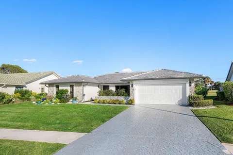 a front view of a house with a garden and yard
