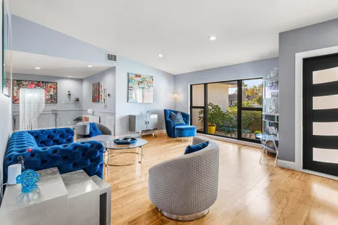 a living room with furniture floor to ceiling window and floor to ceiling window