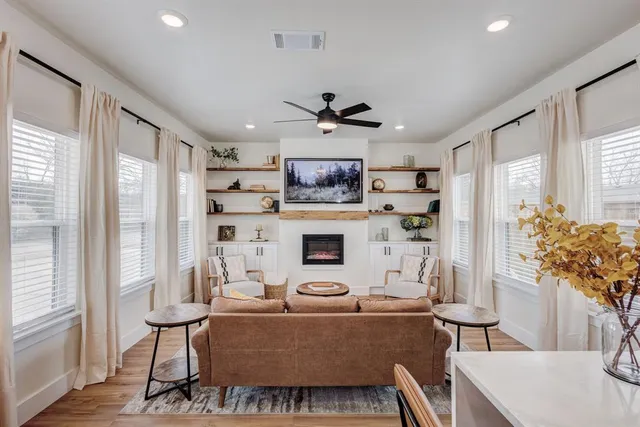 a living room with furniture a fireplace and a potted plant