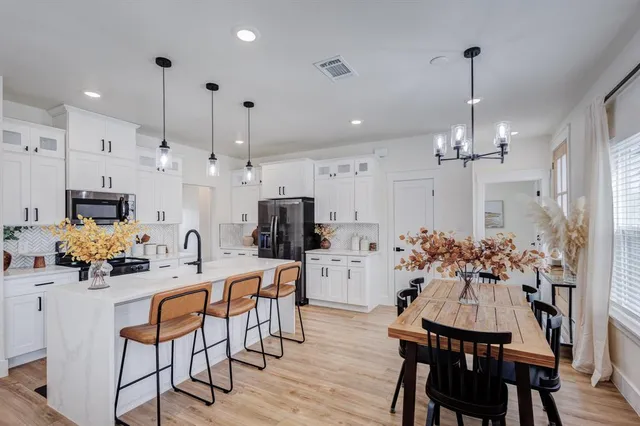 a view of a dining room and kitchen with furniture wooden floor and chandelier