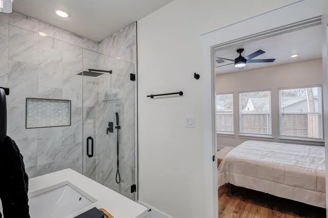 a bathroom with a granite countertop sink a toilet and shower