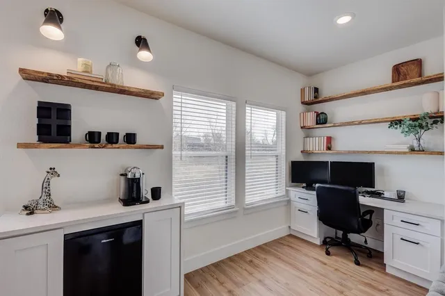 a view of a workspace with furniture and a window
