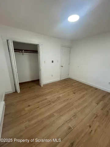 an empty room with wooden floor and cabinet