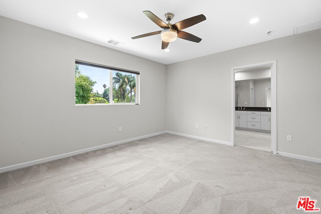 15603 Lilli Way Van Nuys, CA 91406 - Photo 13 of 15 an empty room with windows and a ceiling fan