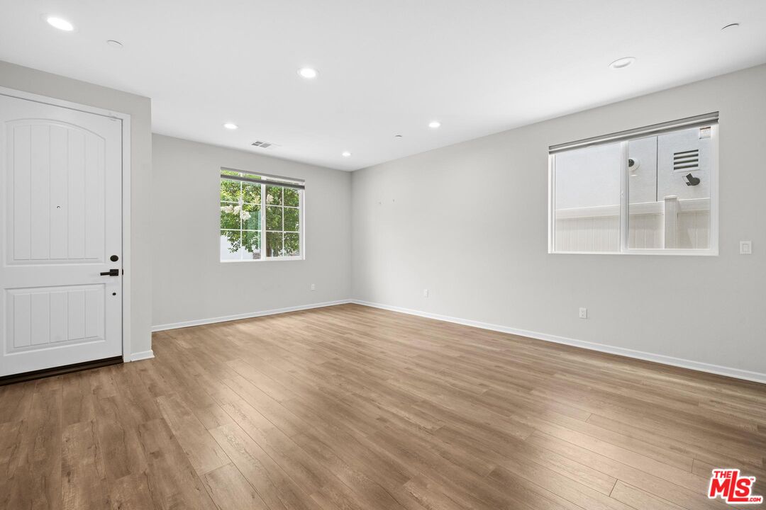 15603 Lilli Way Van Nuys, CA 91406 - Photo 3 of 15 an empty room with wooden floor and windows