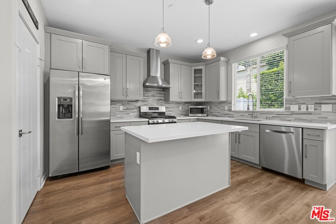 15603 Lilli Way Van Nuys, CA 91406 - Photo 6 of 15 a kitchen with kitchen island a sink stainless steel appliances and window