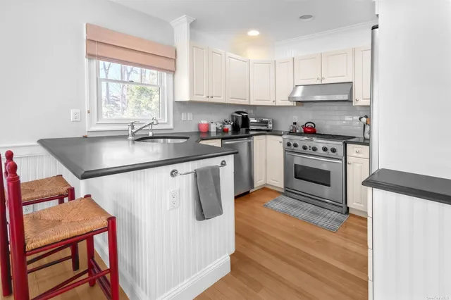 a kitchen with stainless steel appliances granite countertop a stove a sink and a refrigerator