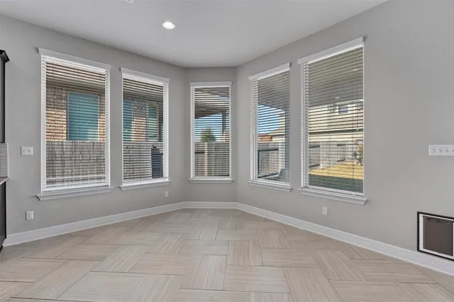 an empty room with a window and a fan