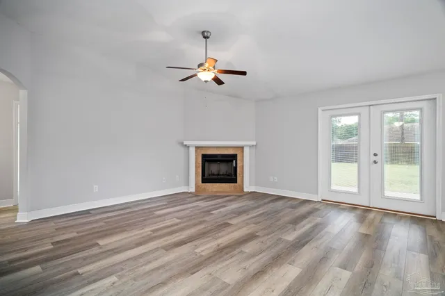a view of empty room with kitchen appliances and wooden floor