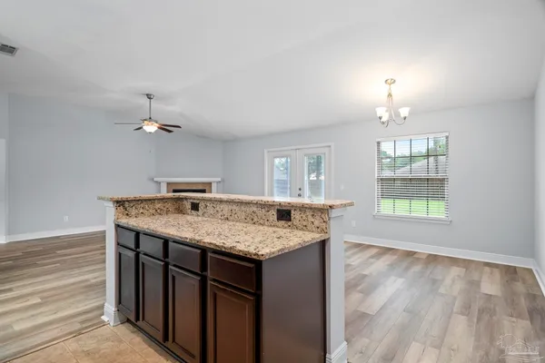 en empty room with windows and ceiling fan