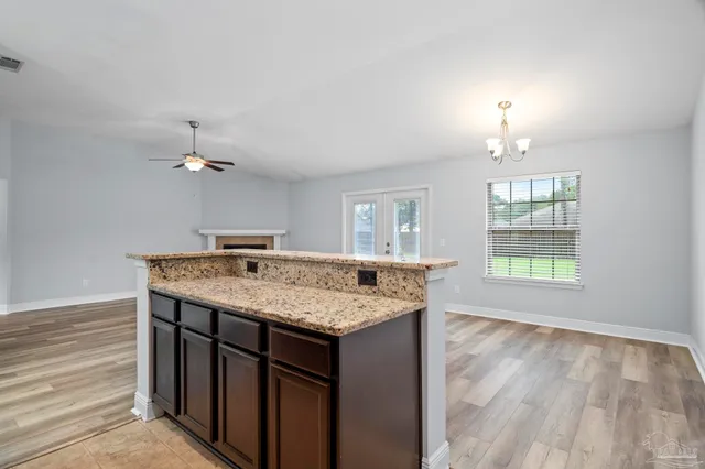 en empty room with windows and ceiling fan