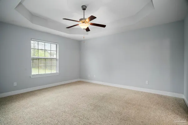 an empty room with closet and a ceiling fan