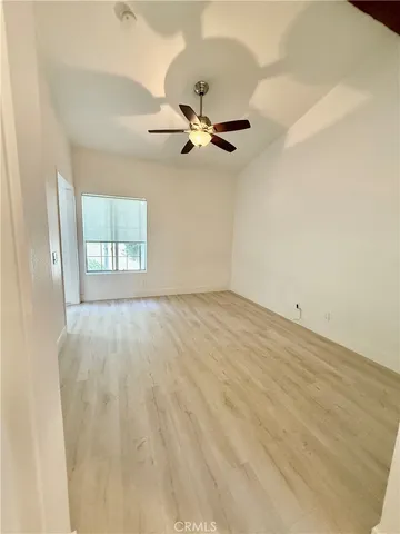 an empty room with windows and fan