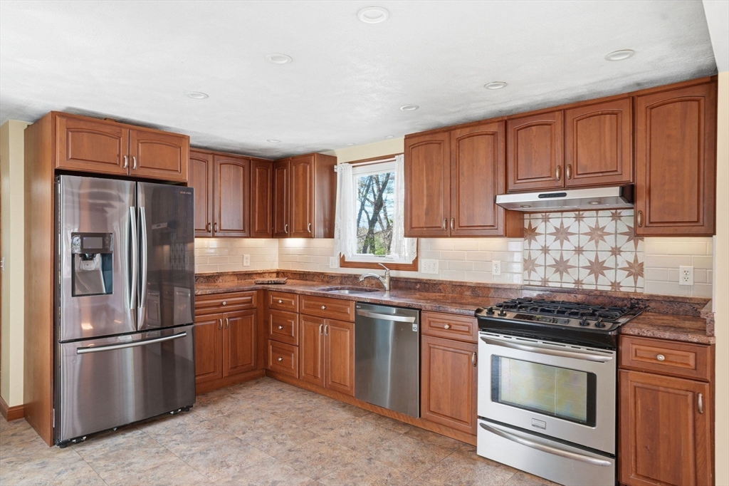3 Fairway Drive Canton, MA 02021 - Photo 4 of 34 a kitchen with stainless steel appliances granite countertop a stove refrigerator sink and cabinets