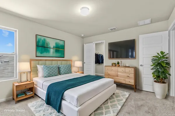 a bedroom with a bed potted plant and flat screen tv