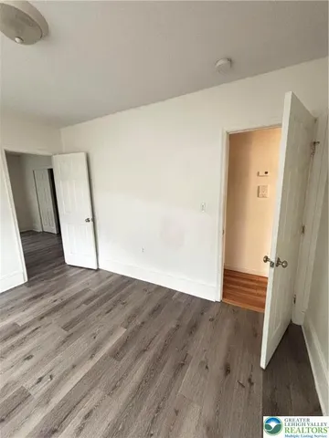 an empty room with wooden floor and staircase