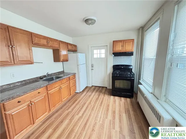 a large kitchen with granite countertop a stove top oven a sink and dishwasher