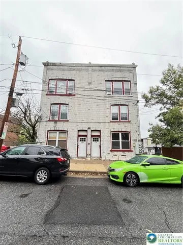 a front view of a house with a garden and parking space