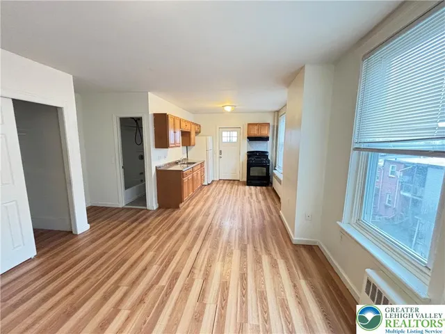 a view of a kitchen with wooden floor and electronic appliances