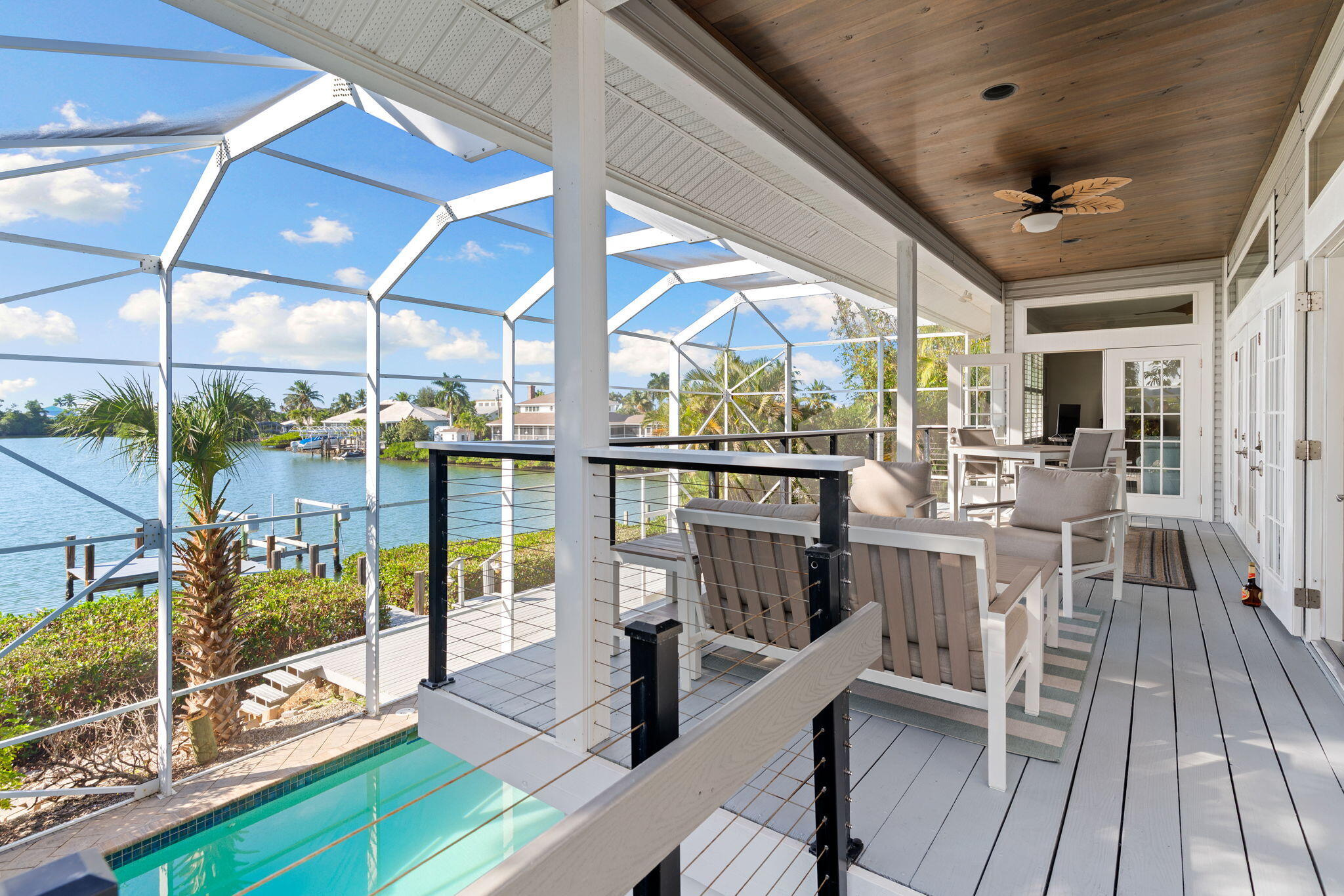 418 Panay Avenue Naples, FL 34113 - Photo 46 of 53 a view of a living room with a floor to ceiling window and wooden floor