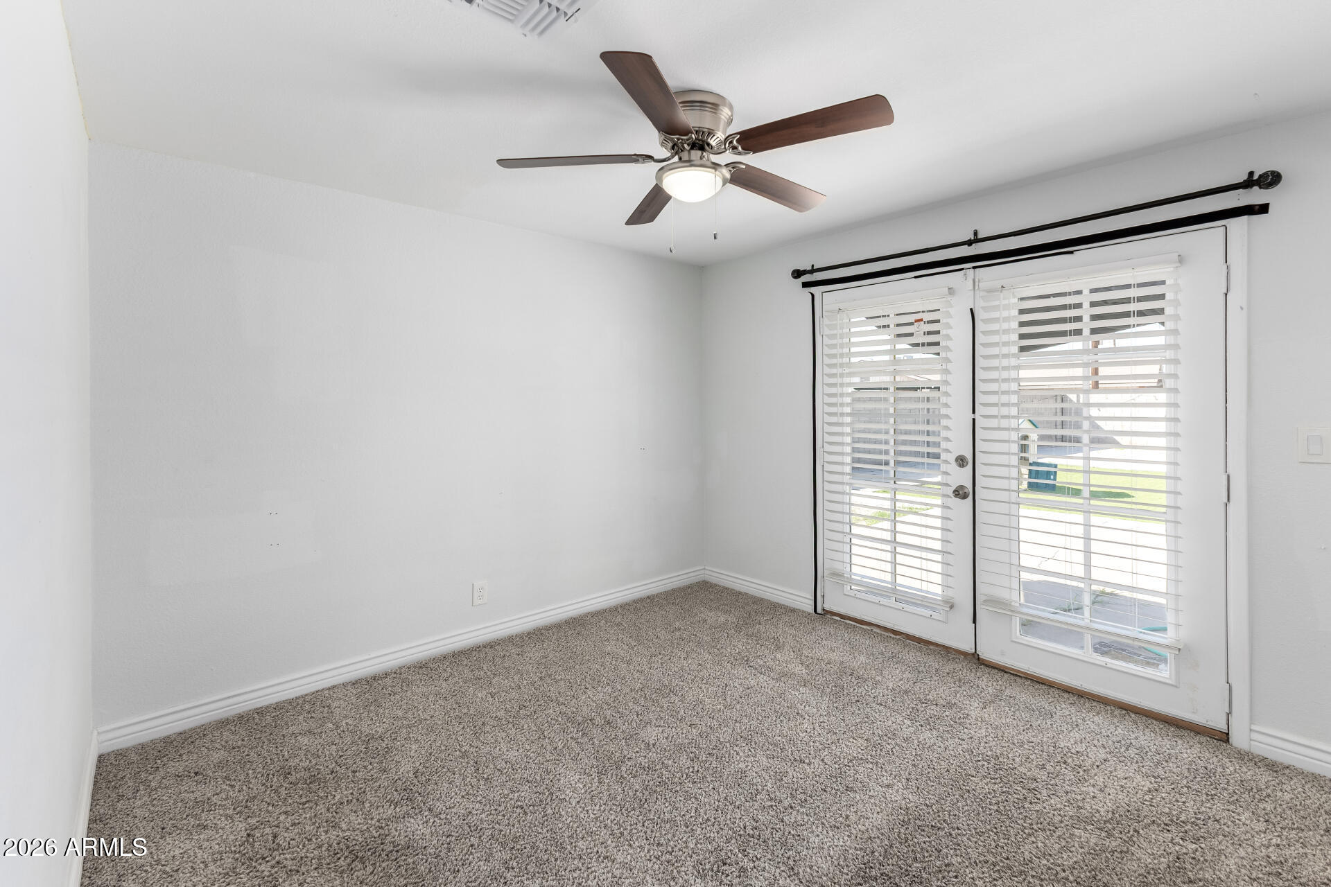 14616 North Ensenada Court Phoenix, AZ 85053 - Photo 13 of 23 an empty room with windows and ceiling fan