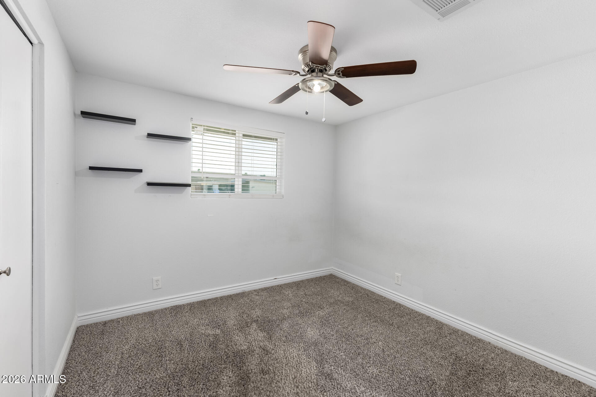 14616 North Ensenada Court Phoenix, AZ 85053 - Photo 17 of 23 an empty room with a window and a fan