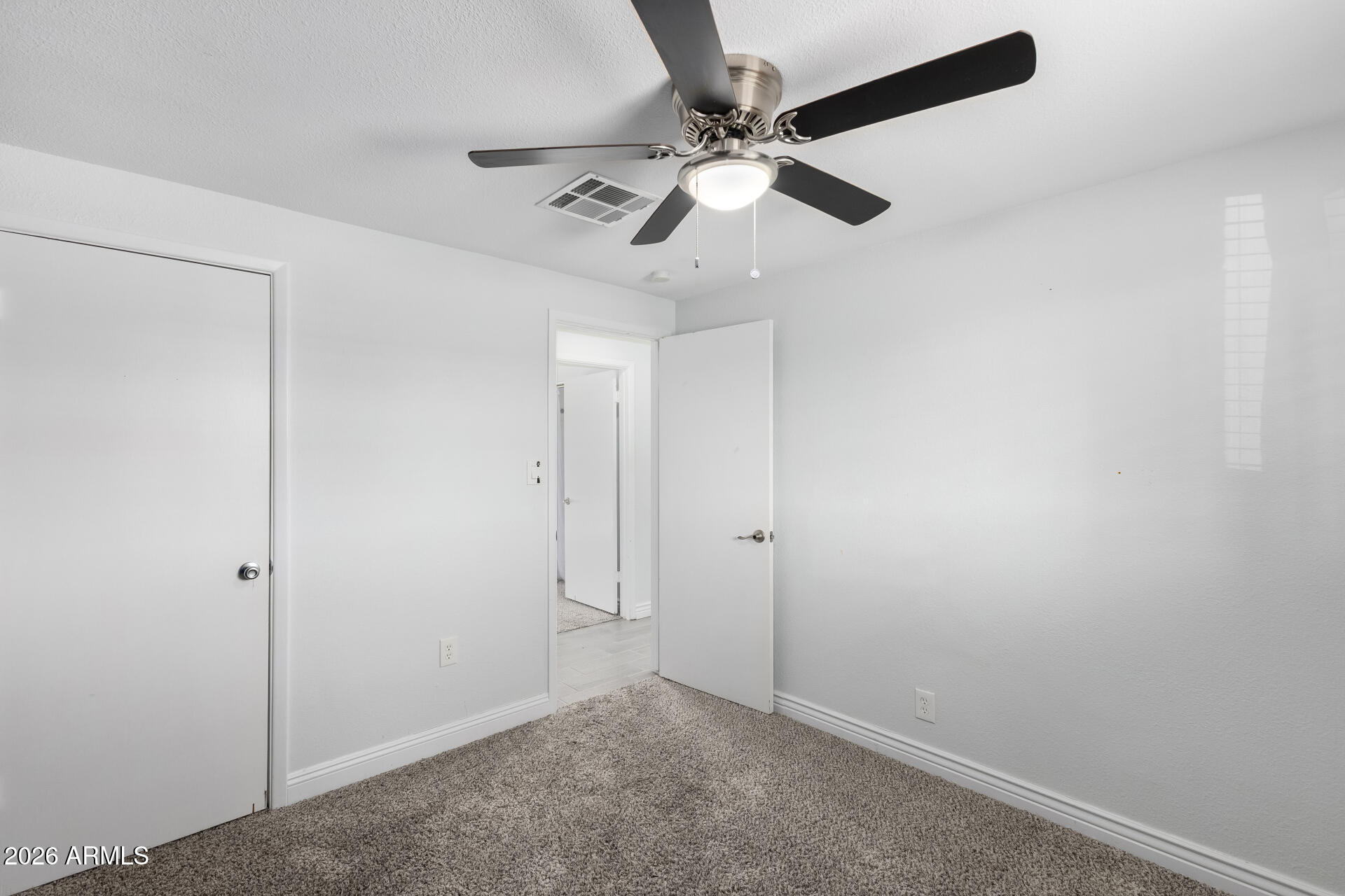 14616 North Ensenada Court Phoenix, AZ 85053 - Photo 18 of 23 an empty room with a window and a fan