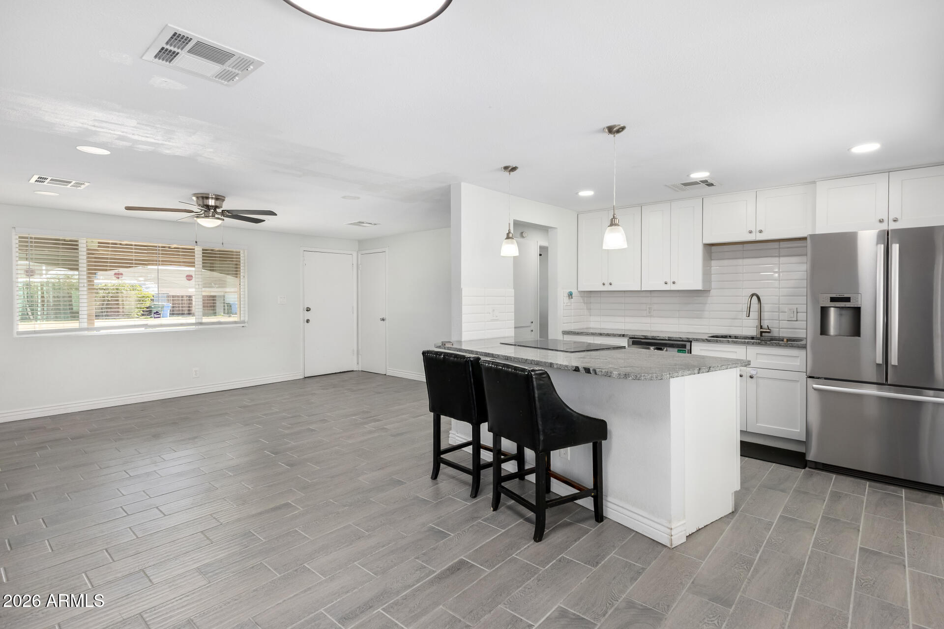 14616 North Ensenada Court Phoenix, AZ 85053 - Photo 8 of 23 a kitchen with a refrigerator and white cabinets
