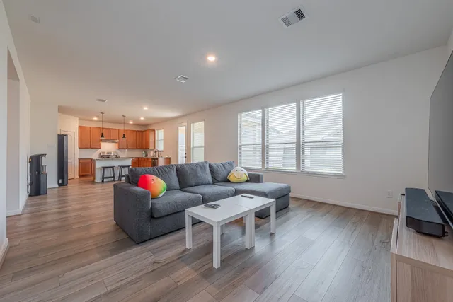 a living room with furniture and a wooden floor