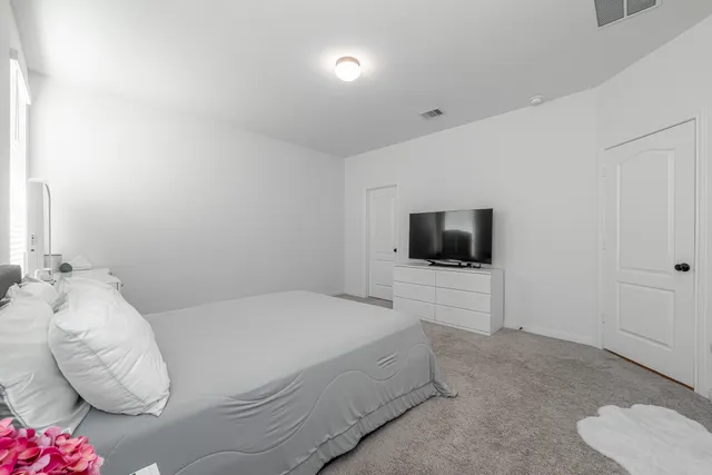 a bedroom with a bed and flat screen tv
