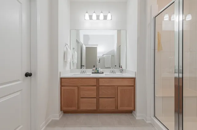 a bathroom with a double vanity sink and a mirror
