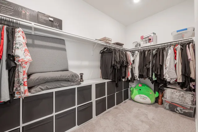 a view of walk in closet with clothes and shoes