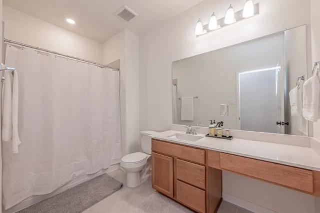 a bathroom with a double vanity sink mirror and toilet