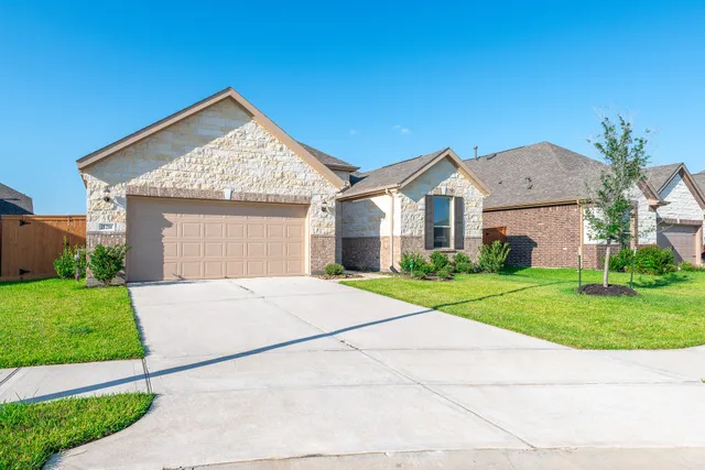a view of a house with brick walls and a yard with plants