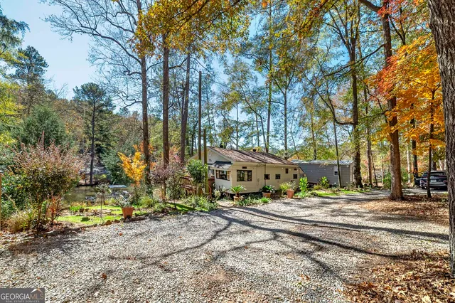 a view of a house with a yard and large trees