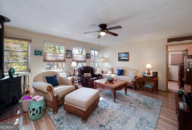 a living room with furniture a flat screen tv and a large window
