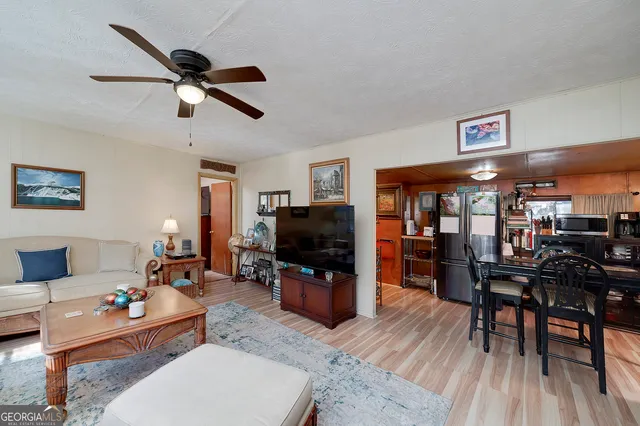 a living room with furniture a flat screen tv and a table