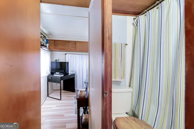 a view of a house with large trees and flower plants