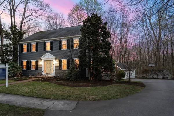 a front view of a house with a yard and tree s