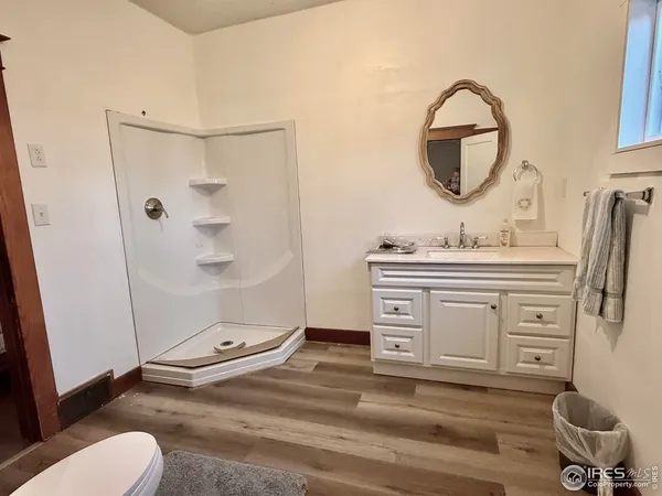 a bathroom with a sink a toilet a mirror and shower