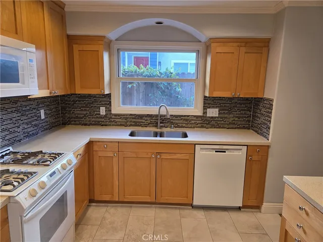 a kitchen with granite countertop a sink stove and cabinets