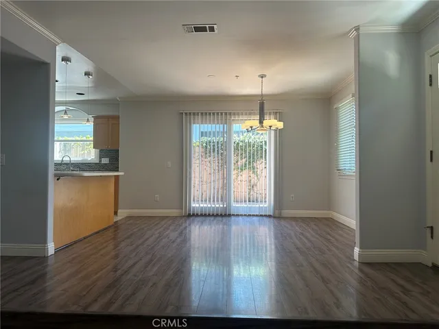 an empty room with wooden floor and outdoor shower