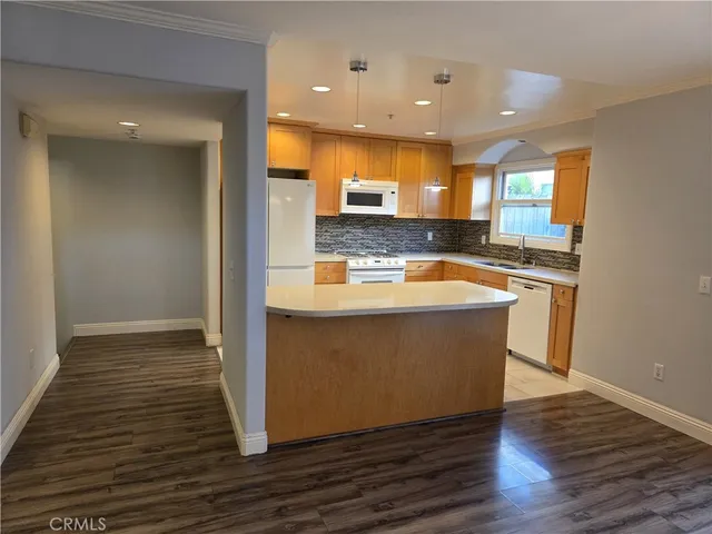 a kitchen with stainless steel appliances granite countertop a sink a stove and a wooden floors