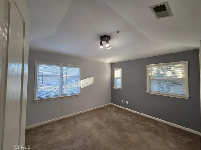 an empty room with windows and closet