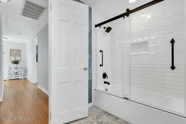 a view of a hallway with front door and wooden floor