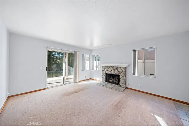 a view of empty room with a fireplace and fan