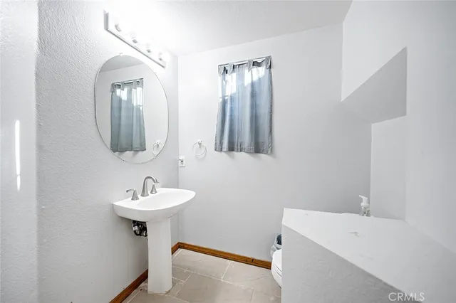 a bathroom with a sink a mirror toilet and bathtub