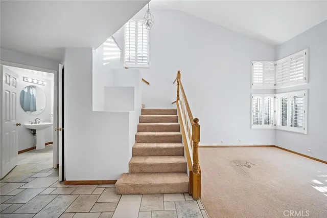 a view of an empty room with stairs and a window