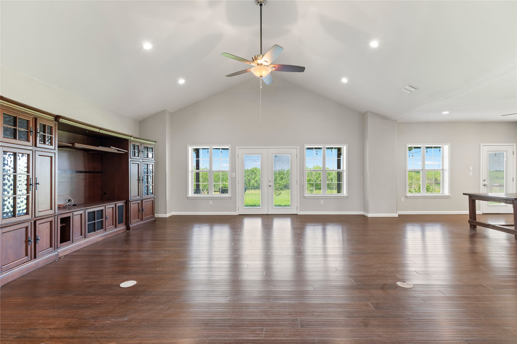 1293 Pioneer Road Seguin, TX 78155 - Photo 22 of 40 Vast living space with vaulted ceilings and gleaming hardwood floors opens to an outdoor landscape.